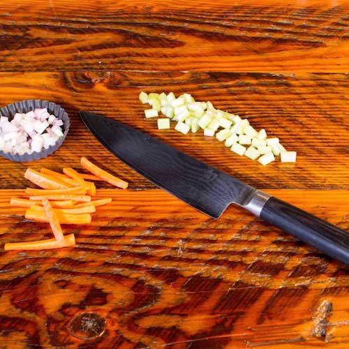 Knife skills: A chef knife on a barnwood table to The Kitchen at Middleground Farms