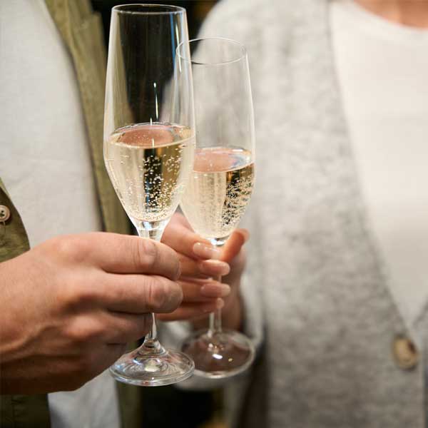 Two people toasting with champagne flutes for Mother's Day